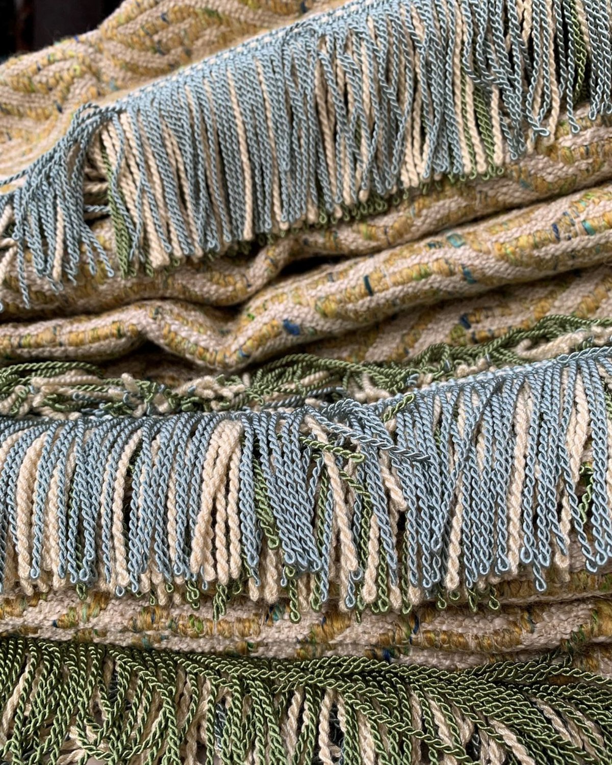 Franjeband in lichtblauw, groen en ecru op geweven koord