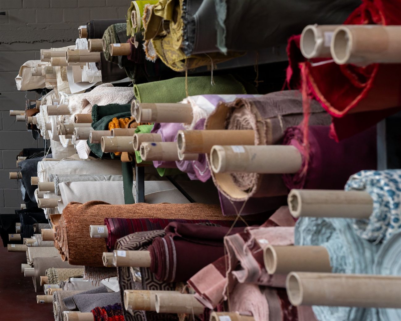 Rijen rollen stof in de fabriekshal