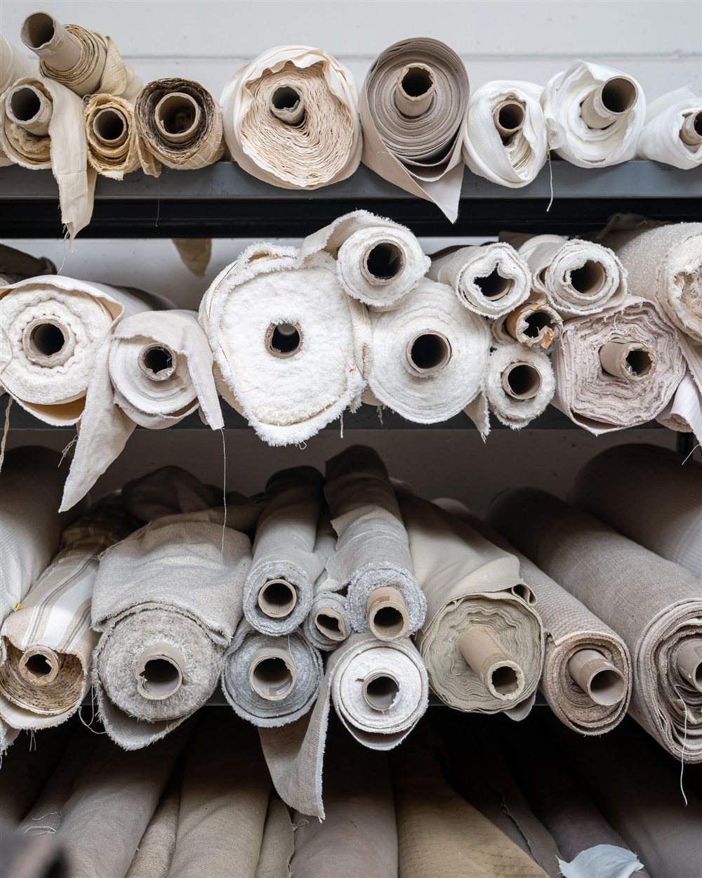 Rollen stof op de rekken in de fabriekshal