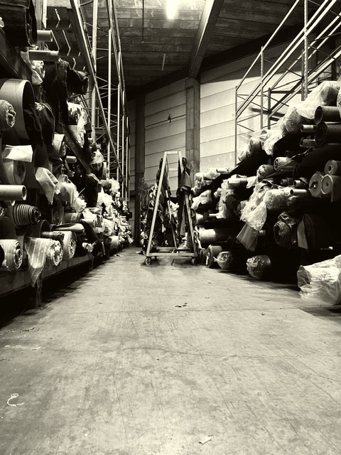 De stock van de fabriekshal, vol rollen stof